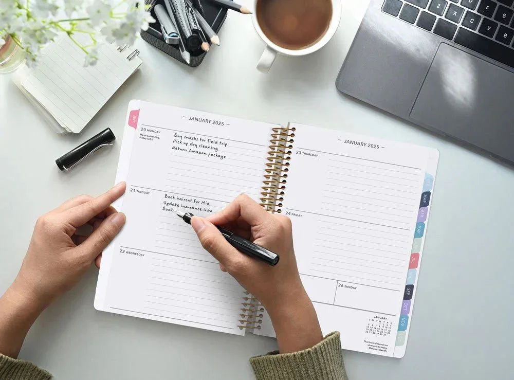 A busy planner lover writing a list in their Posy Paper Co. planner – made to help forgetful minds stay organized with ease.