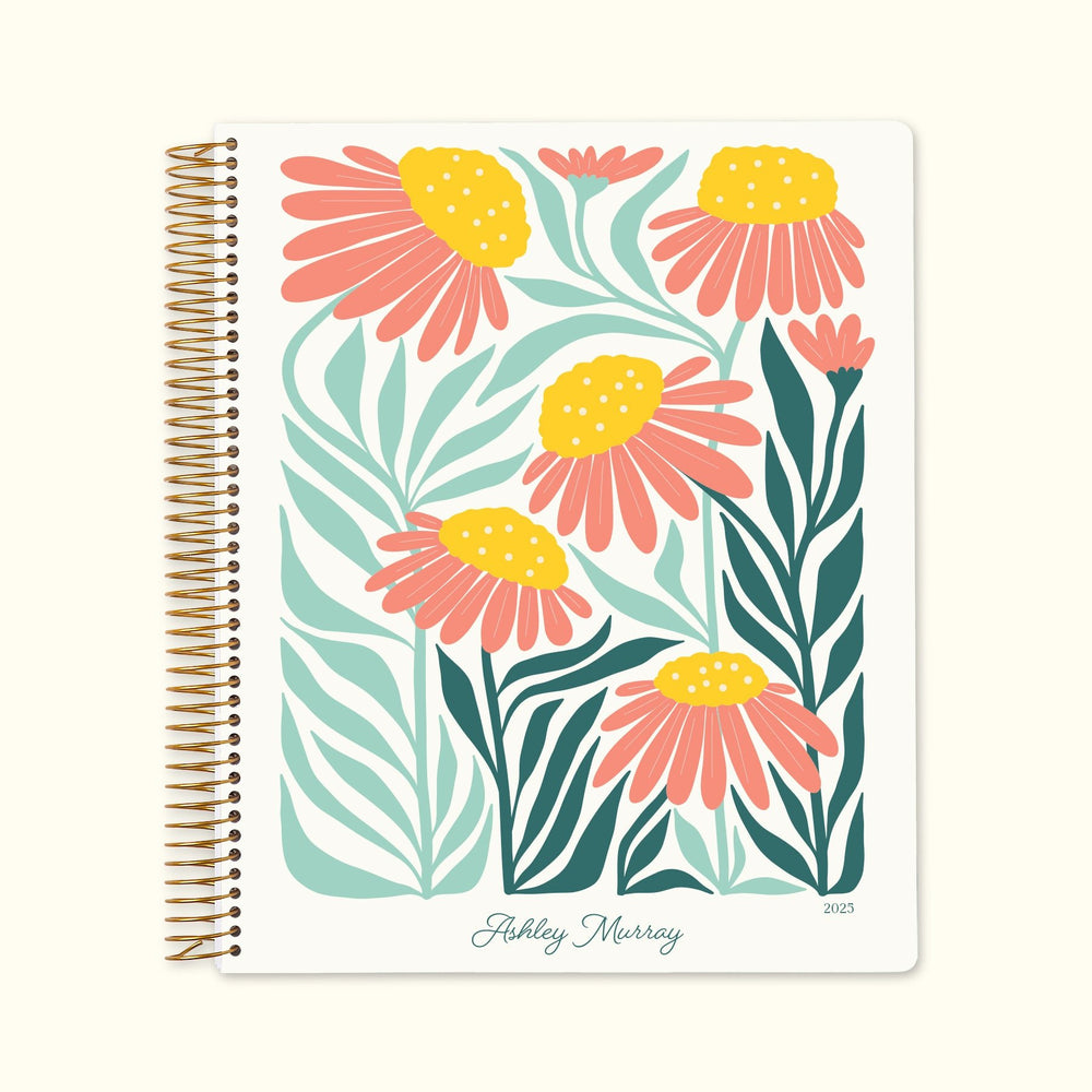 8.5x11 monthly planner with a colorful artful flowers pink, green, and orange cover, blending soft hues with smooth writing paper and structured monthly pages.