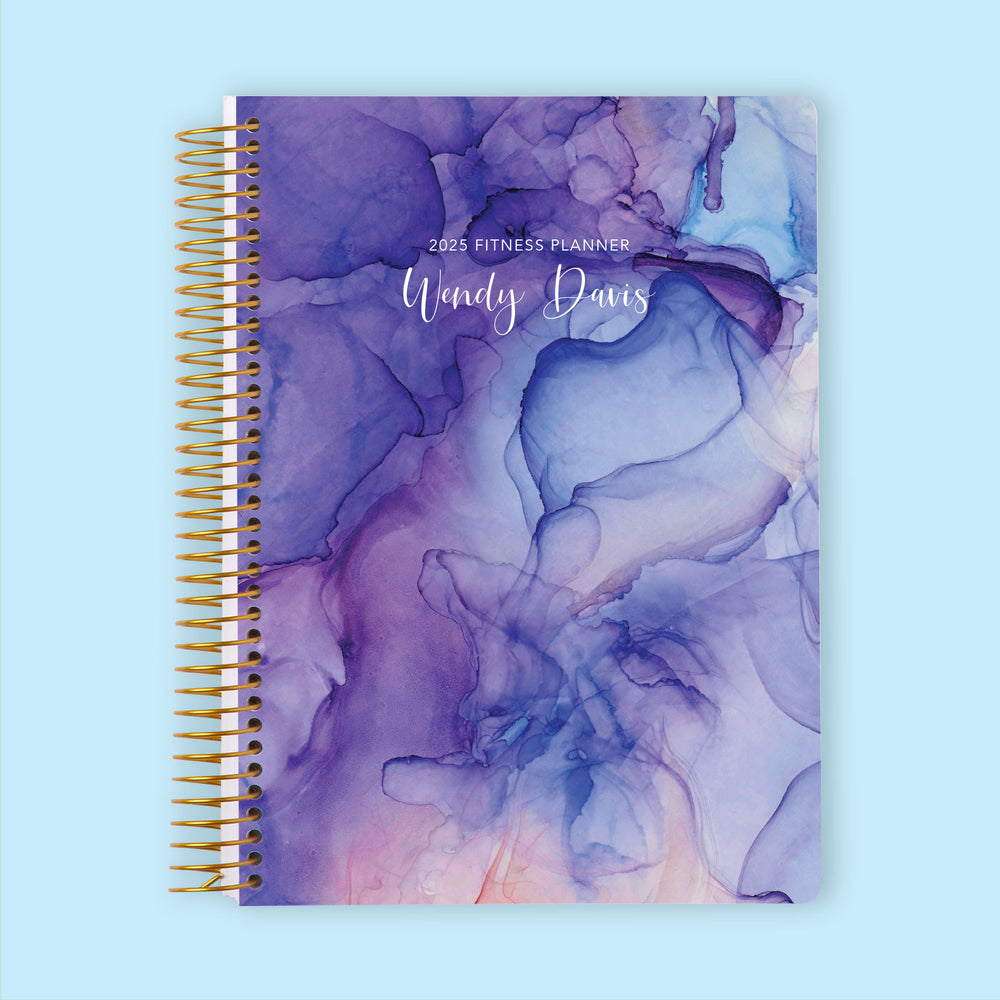 Fitness planner with a Purple Flowing Ink cover, a motivational planner for setting wellness goals and tracking progress.