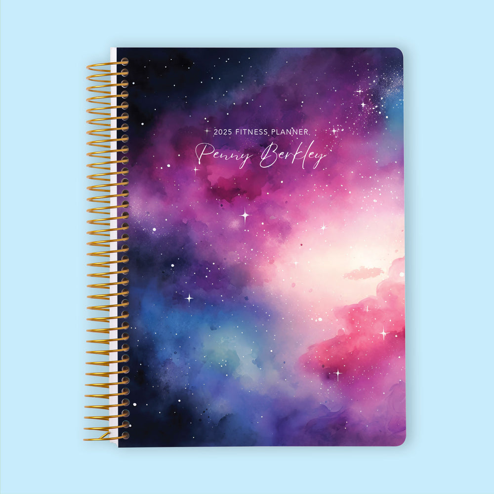 Fitness planner with a Space Galaxy Pink Blue cover, designed for goal-setting, fitness tracking, and weekly progress reviews.