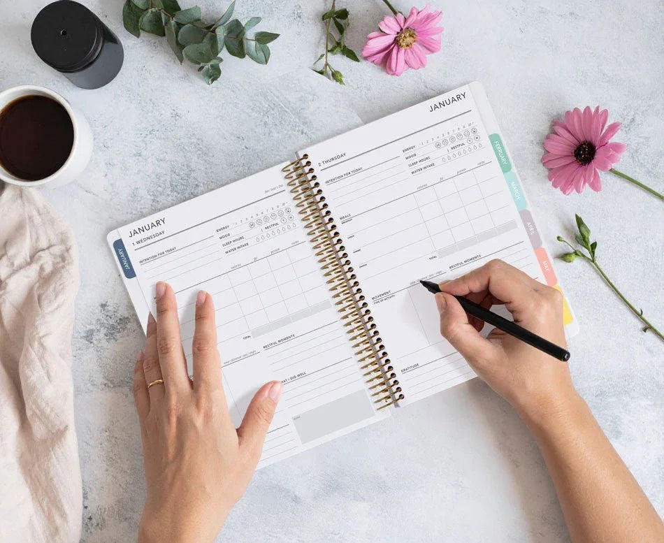 woman writing in her planner as part of her evening ritual: tea, comfy surroundings, soft light