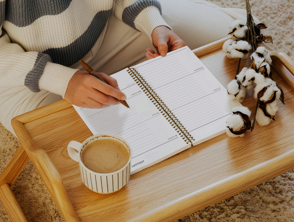 person writing in a paper planner by hand, demonstrating the emotional benefit of handwriting