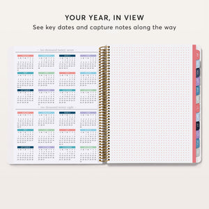 
                  
                    Year-at-a-glance calendar beside a dot-grid notes page in an open planner.
                  
                