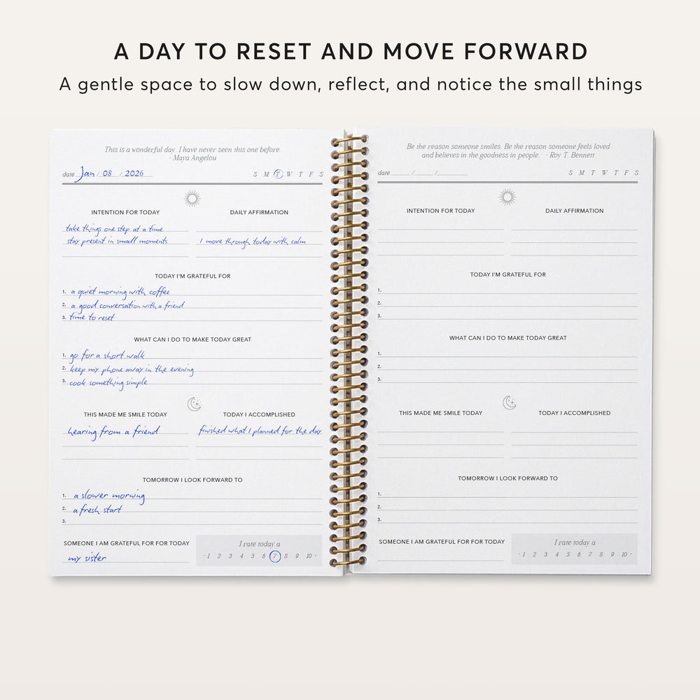 
                  
                    The image is a spiral-bound notebook with a daily intention and gratitude practice page, featuring a blank page for writing down daily reflections and a page for writing down something the person is grateful for.
                  
                