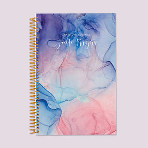 
                  
                    Gratitude journal with a Blue Pink Flowing Ink cover, perfect for setting daily intentions and journaling positive thoughts.
                  
                