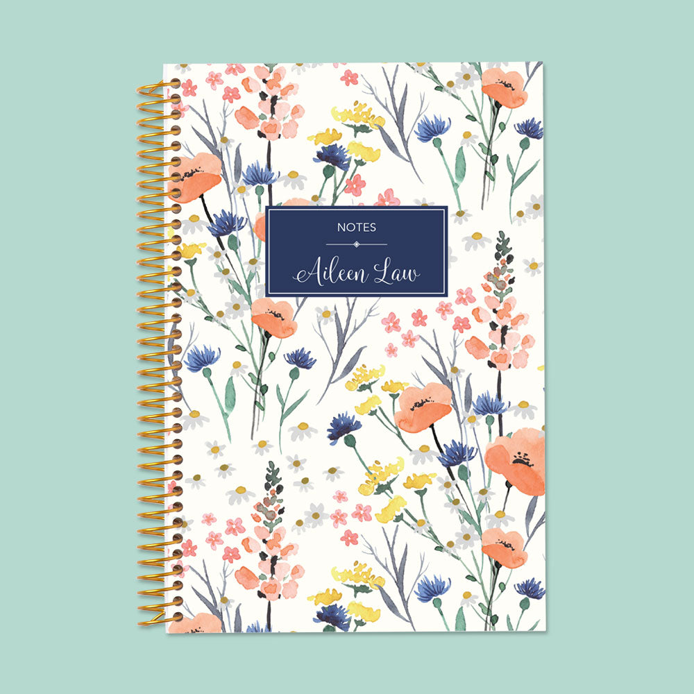 Blue floral notebook with delicate field flowers, premium paper, and sturdy spiral binding—perfect for journaling, planning, and creative notes.