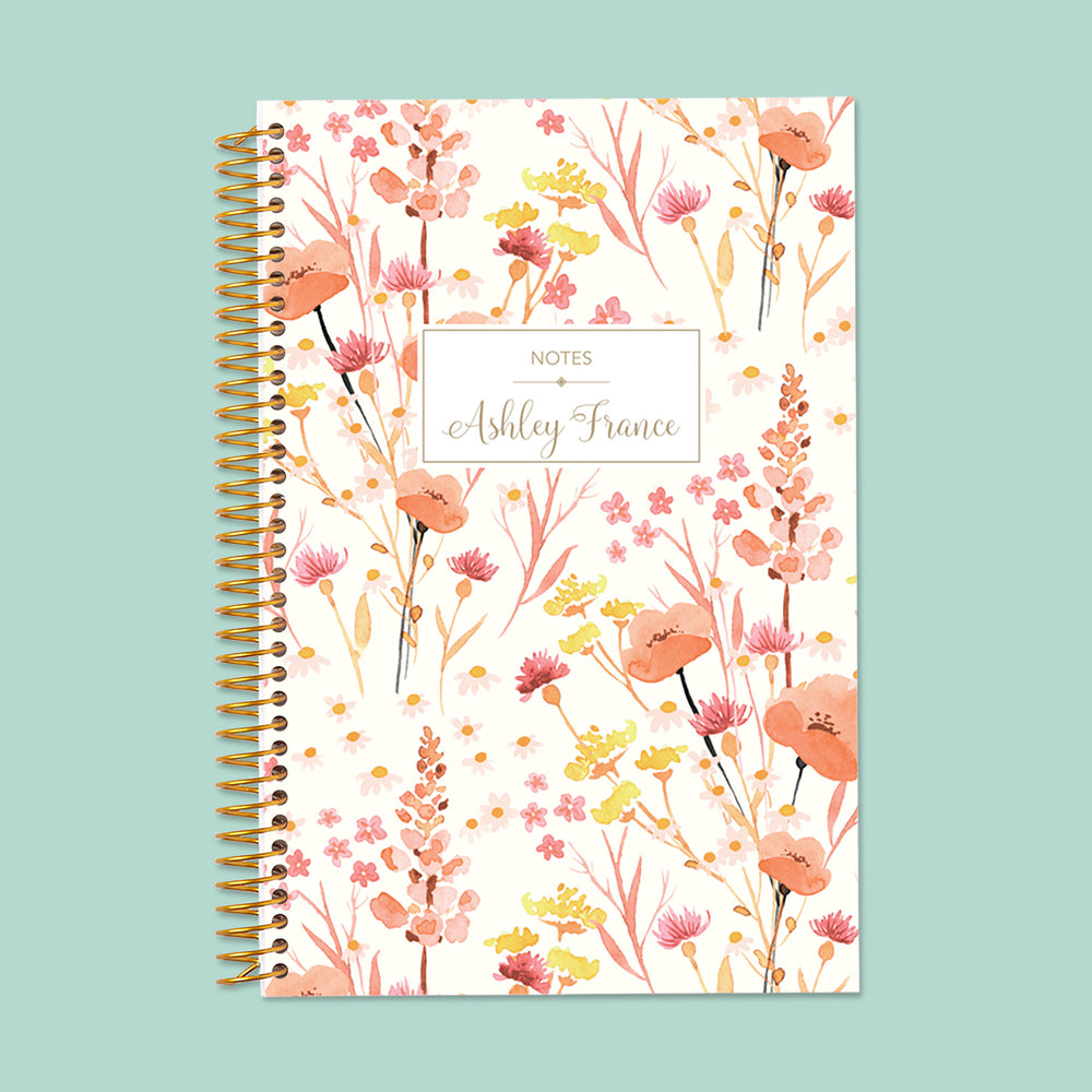 Pink floral notebook with soft field flower illustrations, thick paper, and durable spiral binding—ideal for writing, sketching, or daily journaling.