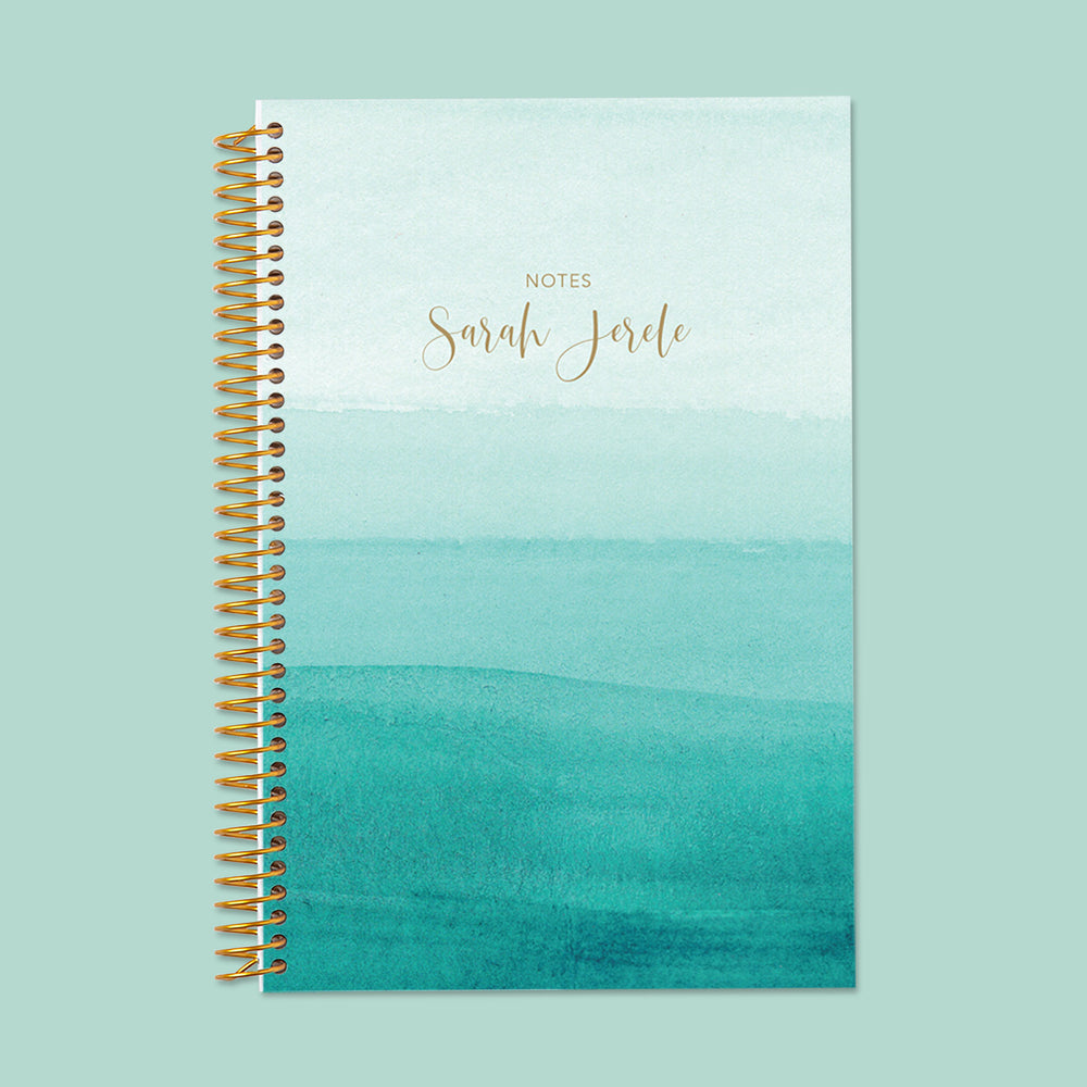 Stylish teal ombre notebook featuring a calming watercolor fade, thick writing pages, and durable spiral binding for daily journaling or note-taking.