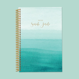 
                  
                    Stylish teal ombre notebook featuring a calming watercolor fade, thick writing pages, and durable spiral binding for daily journaling or note-taking.
                  
                