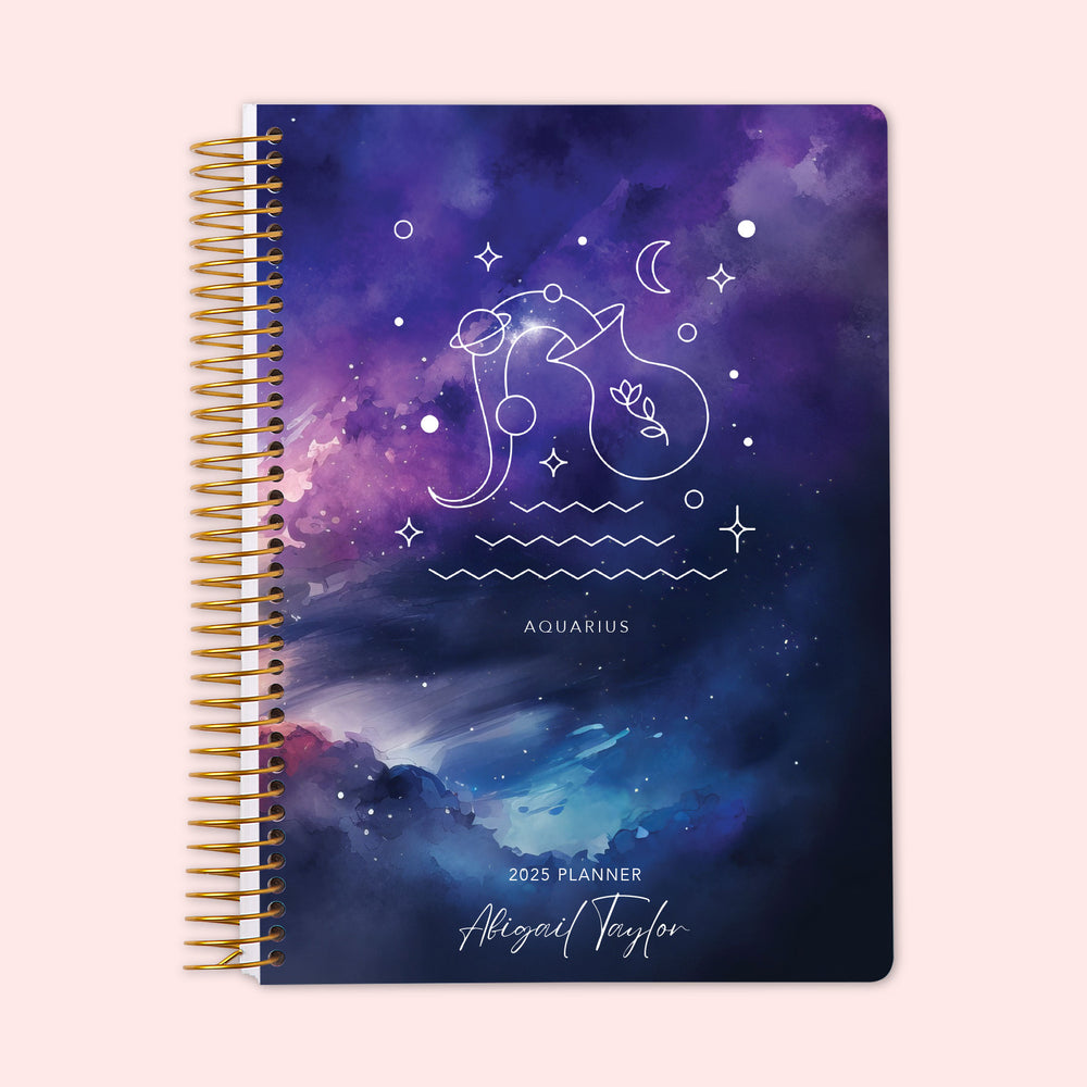 Weekly planner featuring an Aquarius zodiac cover, with the water-bearer constellation shining on a cool cosmic backdrop, finished with a durable coil binding and personalized name on the cover to keep you organized and inspired by the zodiac.