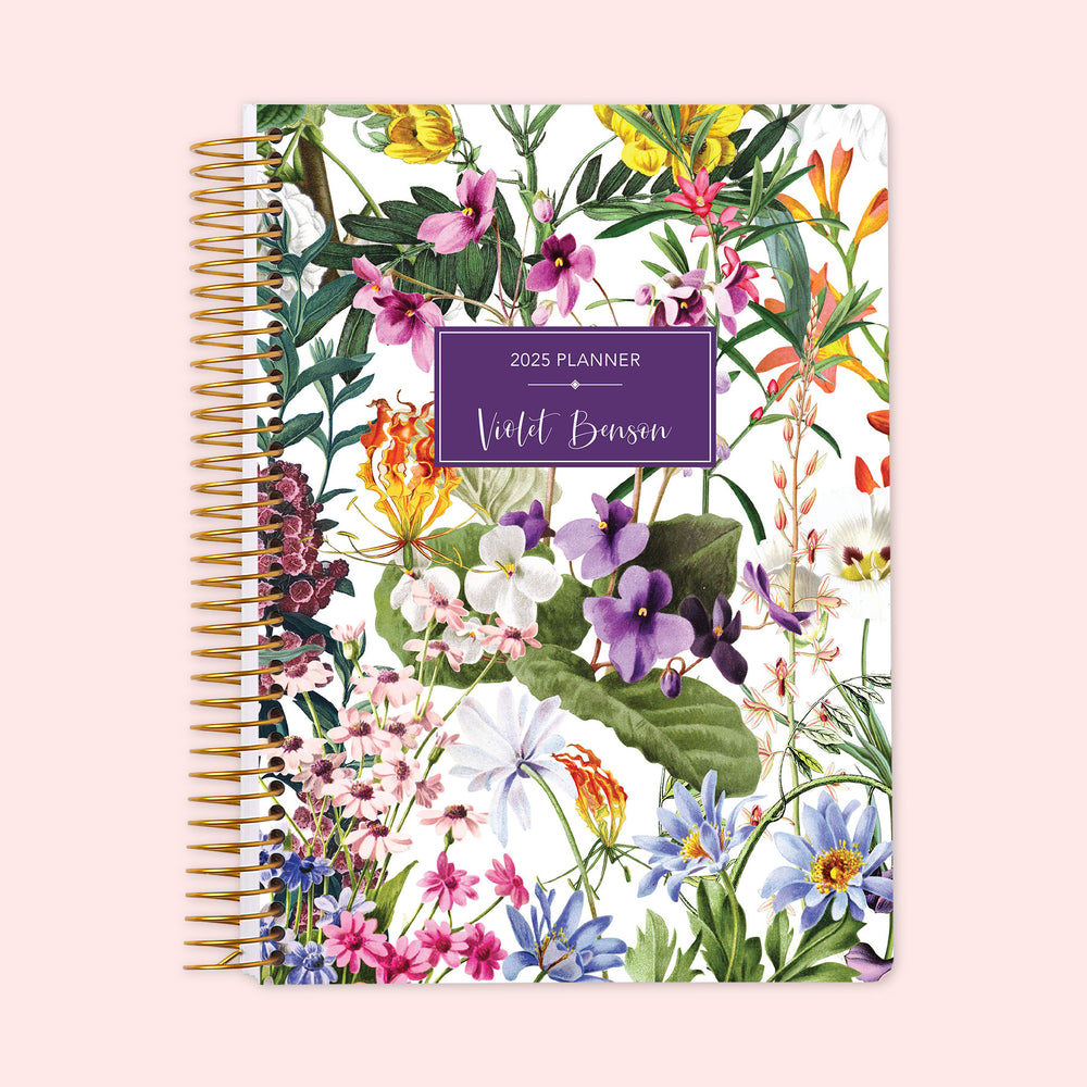 Weekly planner with a cheerful colorful floral cover on a clean white background, showcasing vibrant garden blooms, complete with a strong spiral bind and custom name personalization for an organized, creative week.