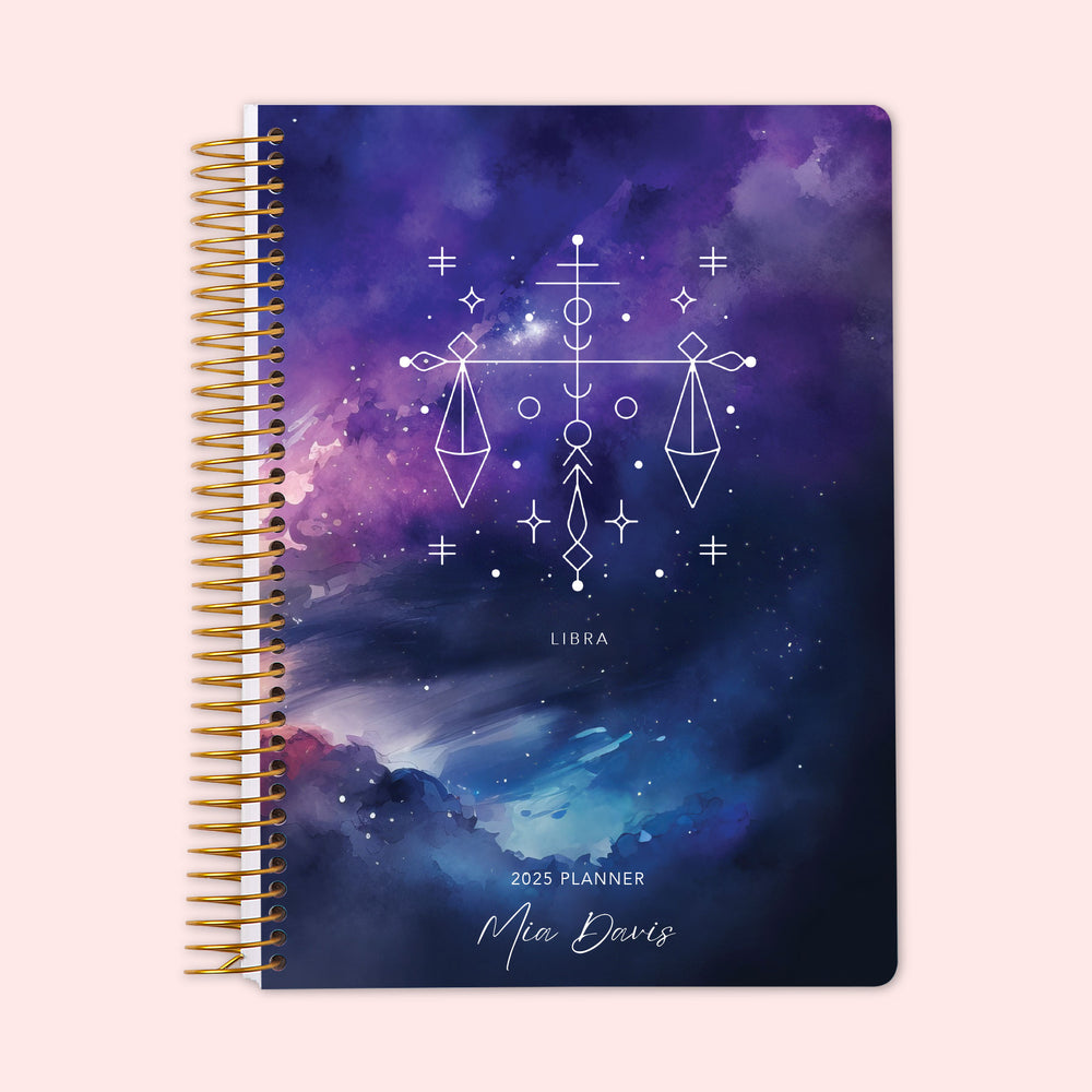 Weekly planner featuring a Libra zodiac cover with the scales constellation over a balanced night-sky palette, protected by a sturdy coil binding and personalized on the cover — ensuring organized planning with astrological flair.