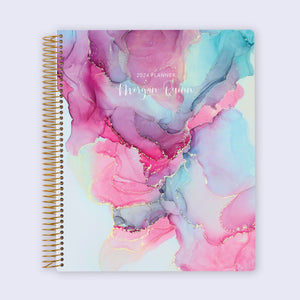 
                  
                    8.5×11 student planner with a Pink Blue Abstract Ink cover and gold coil binding.
                  
                