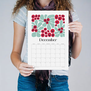 
                  
                    Person holding the December Artful Florals wall calendar with red flowers
                  
                