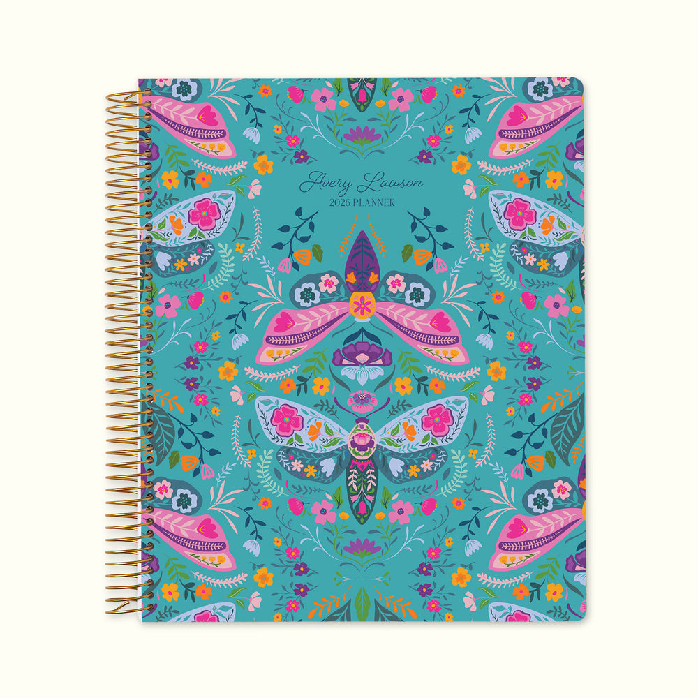 8.5×11 Meadow Daybreak Wings personalized monthly planner with customizable start month, gold coil binding, and a whimsical teal floral cover featuring illustrated moths, butterflies, and garden accents.