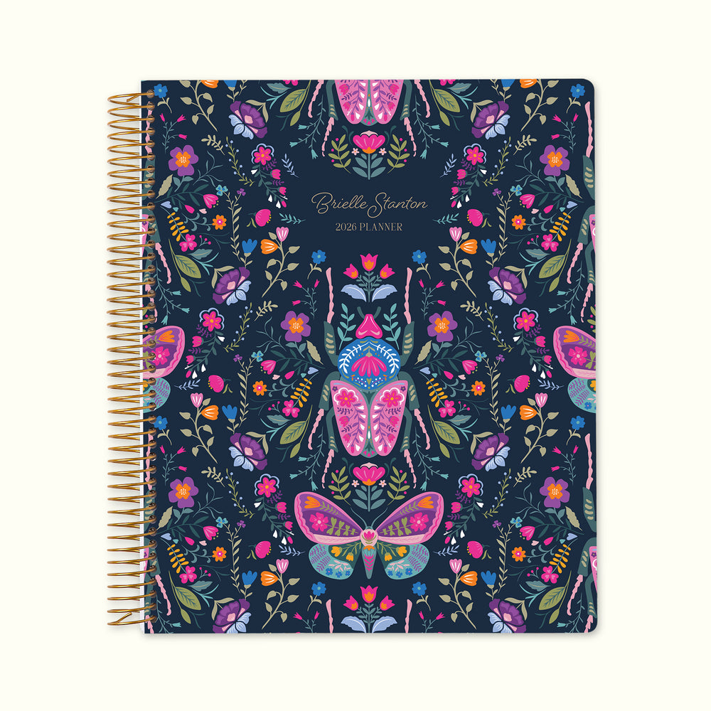 8.5×11 Midnight Garden Wings personalized monthly planner with customizable start month, gold coil binding, and a deep navy floral cover featuring illustrated butterflies, moths, and vibrant garden botanicals.