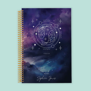 
                  
                    Pisces zodiac notebook featuring a mystical blue-purple cover, lined pages for creative expression, and durable spiral binding for capturing inspiration.
                  
                