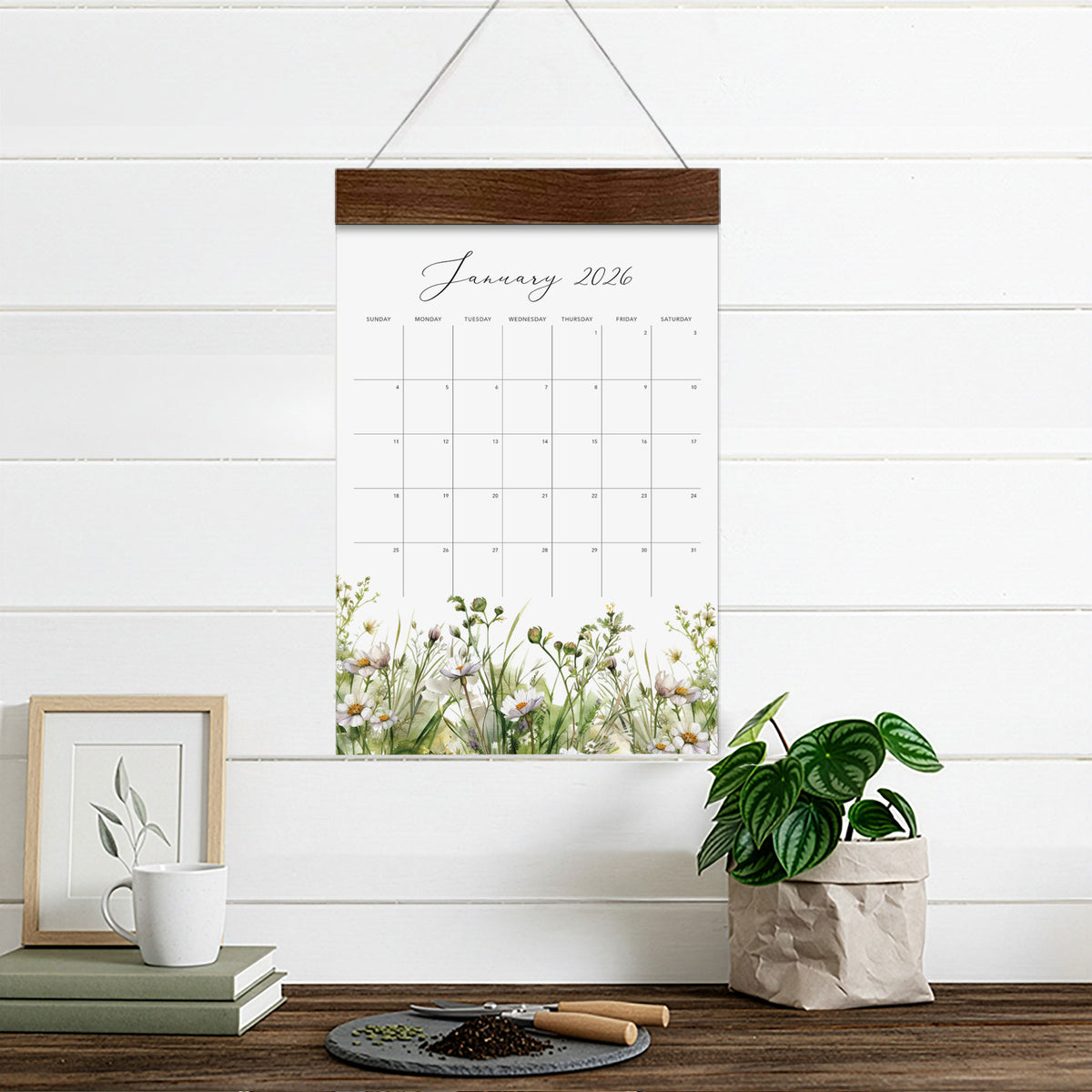Meadow Floral wall calendar showing a January 2026 page above a desk