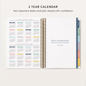 
                  
                    Two-year calendar beside a quote page in an open daily planner.
                  
                