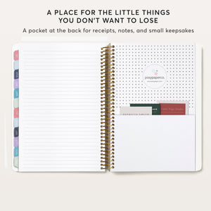 
                  
                    Planner back pocket holding cards beside a lined notes page.
                  
                