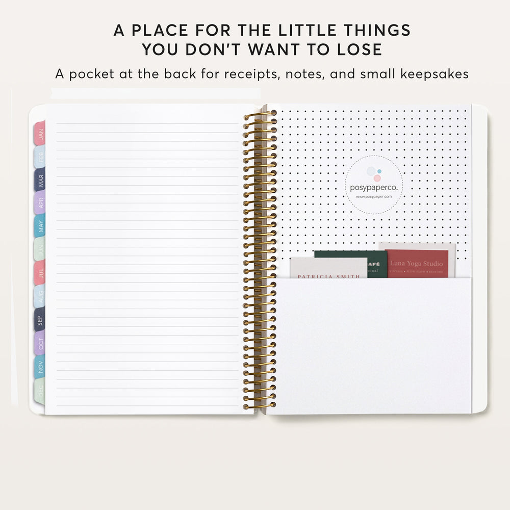 
                  
                    an open spiral-bound notebook with blank lined pages, and a pocket at the back for storing small items like receipts, notes, and small keepsakes.
                  
                