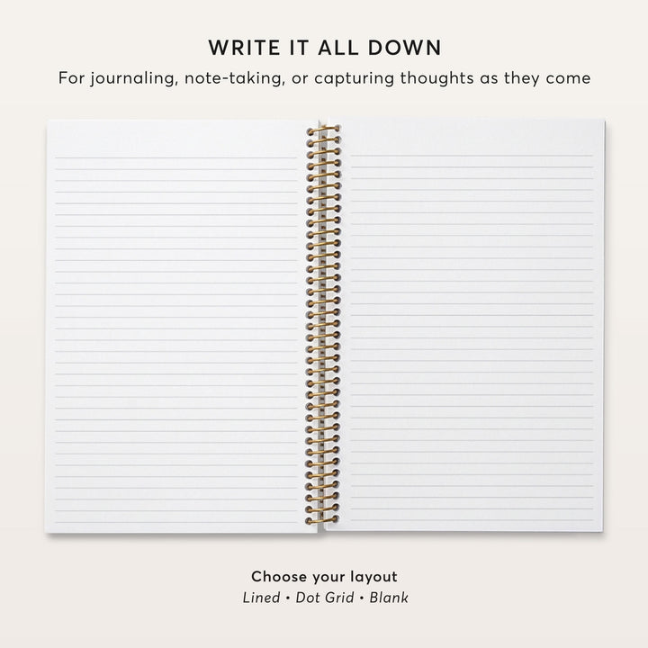 Open notebook showing lined pages and gold coil binding.