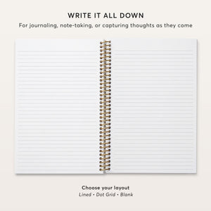 
                  
                    Open notebook showing lined pages and gold coil binding.
                  
                