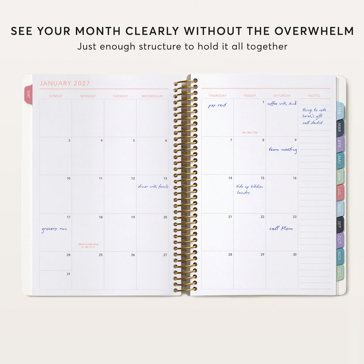 Open monthly planner showing a filled-in calendar spread, notes column and colored month tabs.