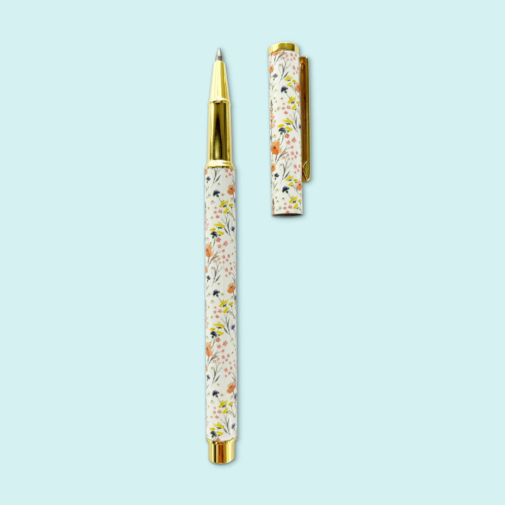 
                  
                    Posy Paper Co. field flowers blue rollerball point pen with cap off.
                  
                