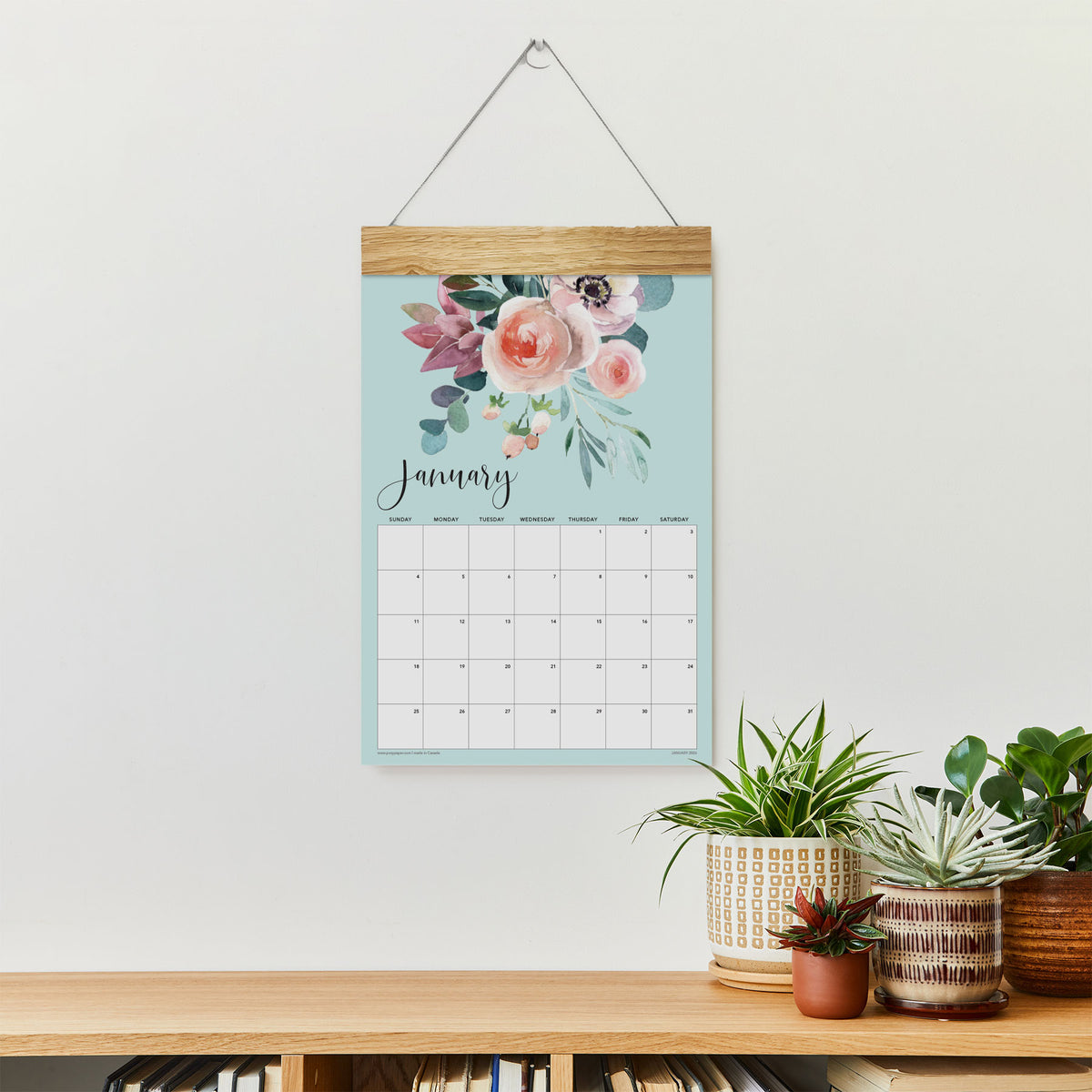Floral January wall calendar with watercolor roses hanging above a console