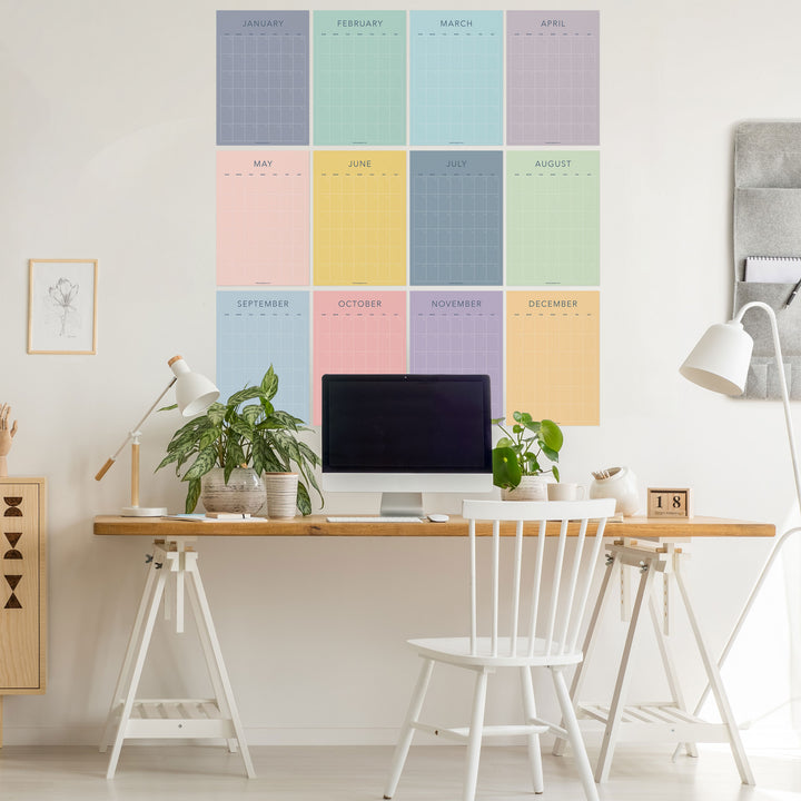 Pastel undated wall calendar with all twelve months displayed above a desk