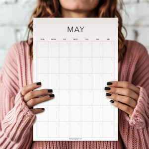 
                  
                    Person holding a white May undated wall calendar sheet
                  
                