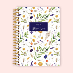
                  
                    Recipe book with a personalized navy label, yellow and purple botanical cover and gold coil binding.
                  
                