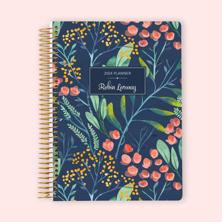 Weekly planner with an elegant navy watercolor floral cover, showcasing soft painted blossoms on a dark background, finished with a durable coil binding and customizable with your name for organized planning with artistic flair.