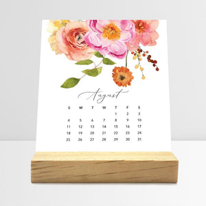 
                  
                    August Flirty Florals desk calendar card with watercolor flowers in a wooden stand.
                  
                