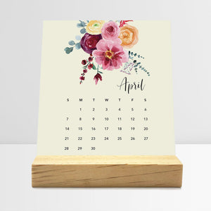
                  
                    April Floral desk calendar card with watercolor flowers in a wooden stand.
                  
                