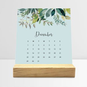 
                  
                    December Floral desk calendar card with watercolor flowers in a wooden stand.
                  
                
