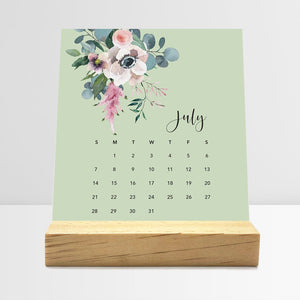 
                  
                    July Floral desk calendar card with watercolor flowers in a wooden stand.
                  
                