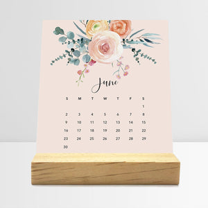 
                  
                    June Floral desk calendar card with watercolor flowers in a wooden stand.
                  
                