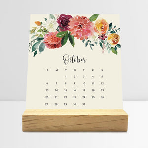 
                  
                    October Floral desk calendar card with watercolor flowers in a wooden stand.
                  
                